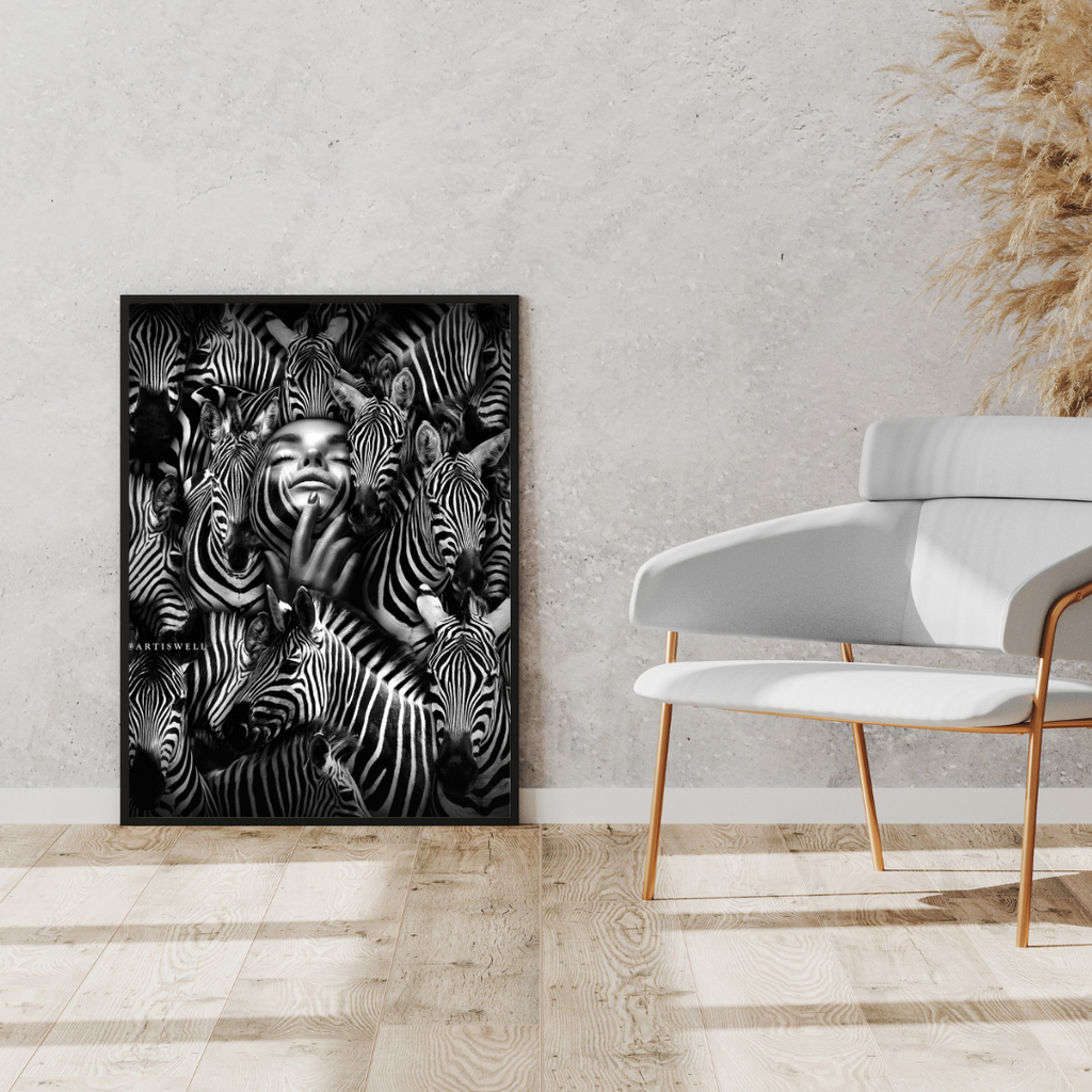 Framed artwork of zebras on a wall in a modern interior setting with a white chair and decorative plants.