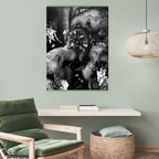 Living room with a green armchair, woven stool, and wall art of elephants and flowers.